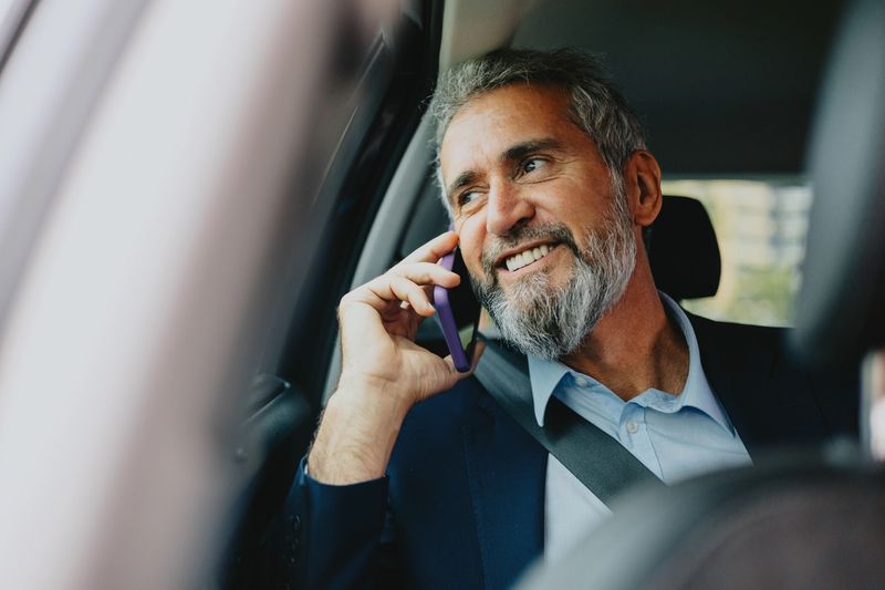Businessman on phone in the back seat of an Elite Coastal Rides Port St. Lucie chauffeur service SUV
